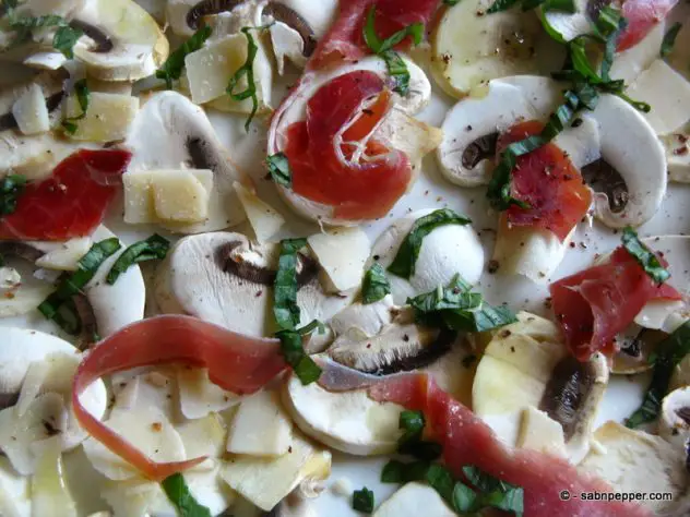 des copeux de parmesan, du jambon de parme et voilà une salade de champignons version Italie